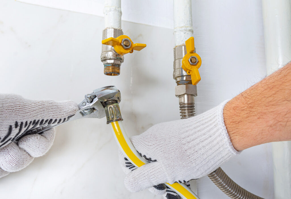 Maintenance Engineer Replacing Reinforced Propane Gas Hose Due To Gas Leak At Home Boiler Room.